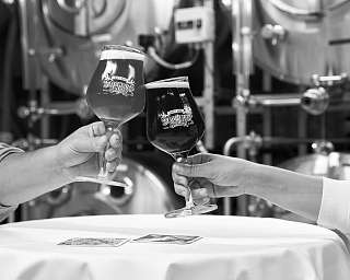 Zwei Männer stoßen mit Engel- und Teufelbier an